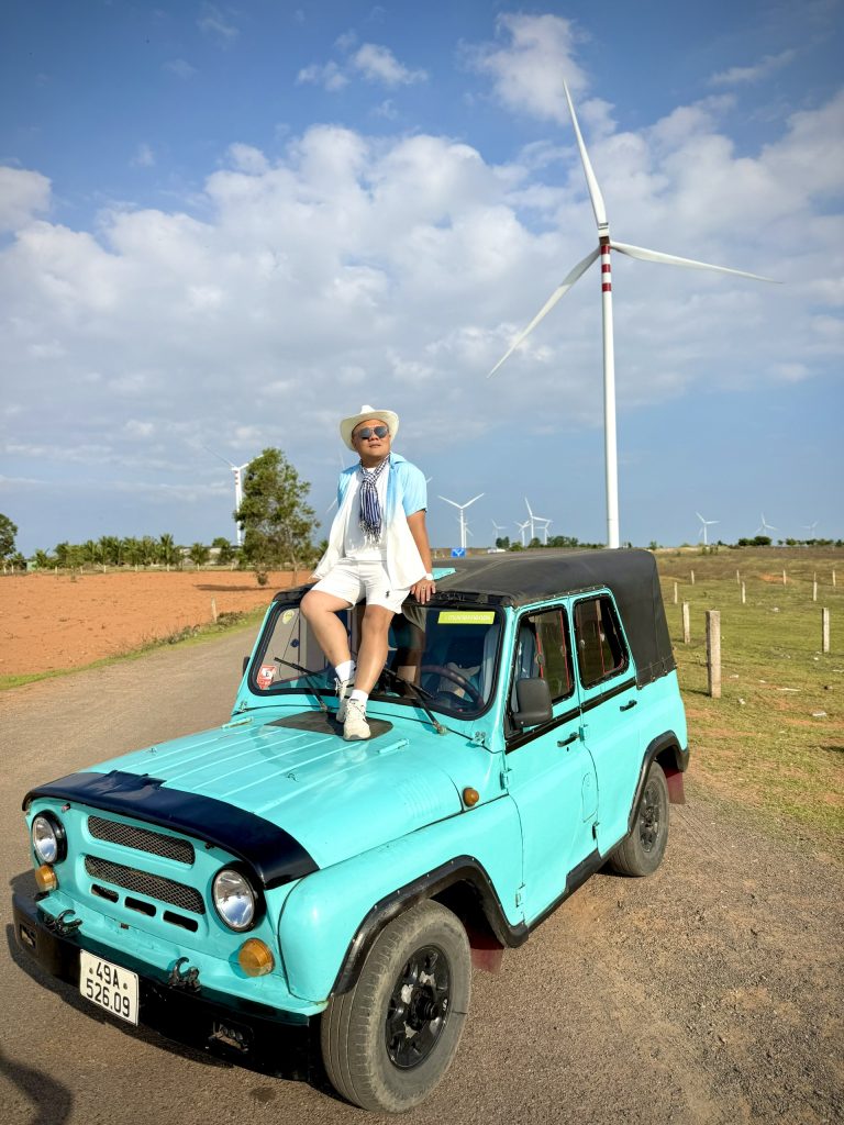 Tourist posing with a Jeep at Wind Turbines Mui Ne