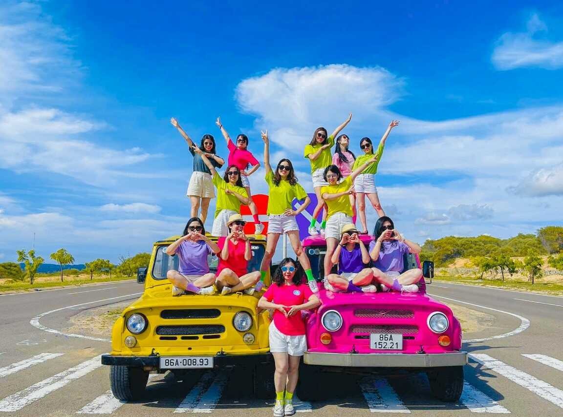 nhóm khách chụp ảnh với xe jeep